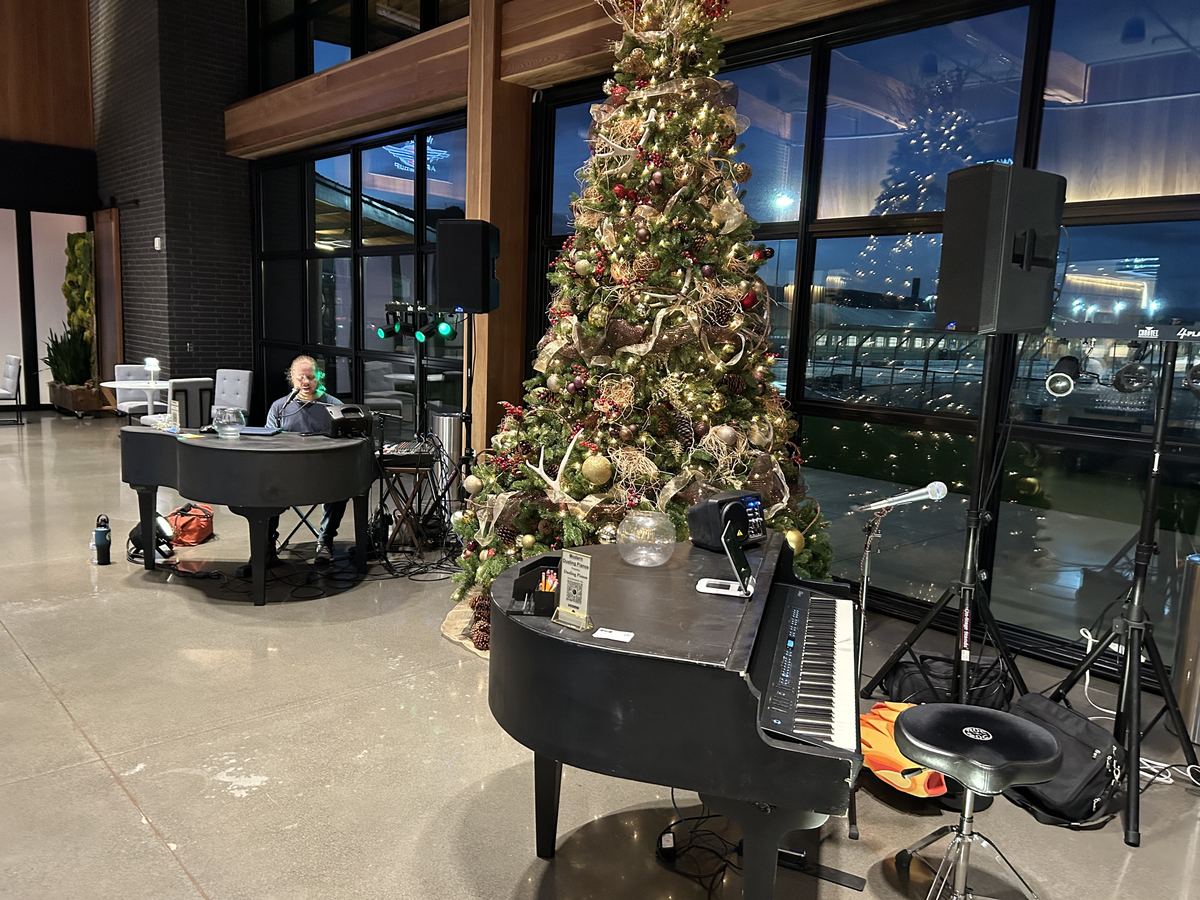 Holiday corporate lobby with two pianos and a Christmas tree