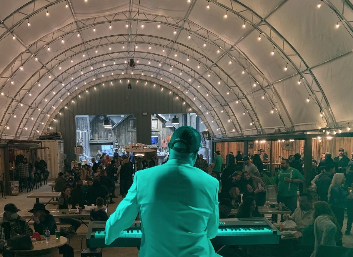 Live piano performance under fairy-light venue ceiling